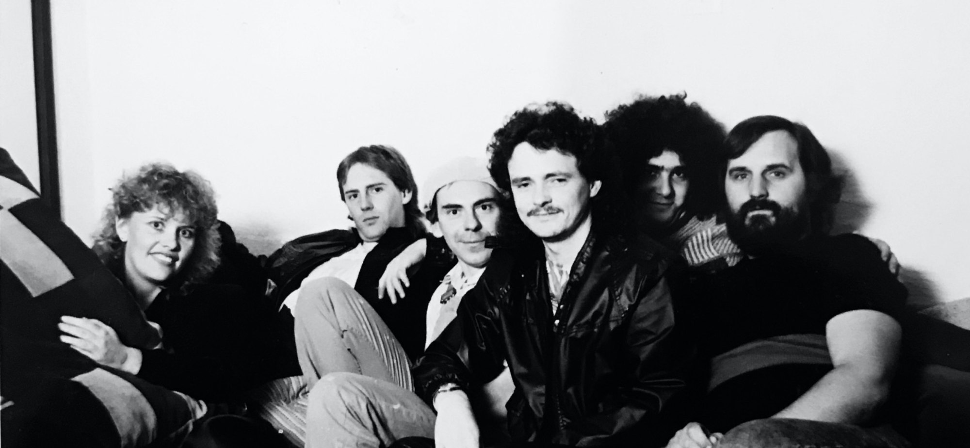 The six members of Mistaken Identity photographed together on a couch for a band promo shot.